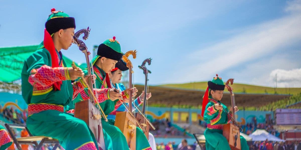 Musicians in traditional dress performing on morin khuur at the Naadam Festival