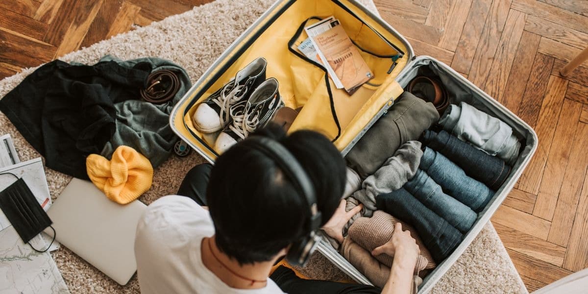 An open suitcase being packed with layered clothing for a Mongolia trip